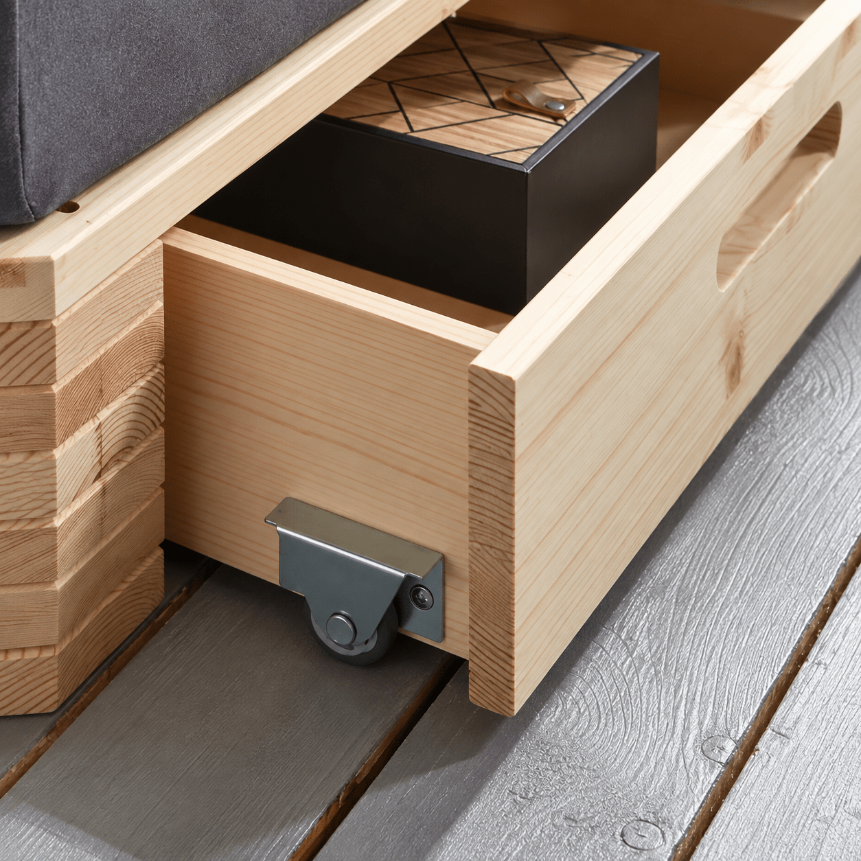 Opberglade op wieltjes aan voeteneinde van houten palletbed 90x200
